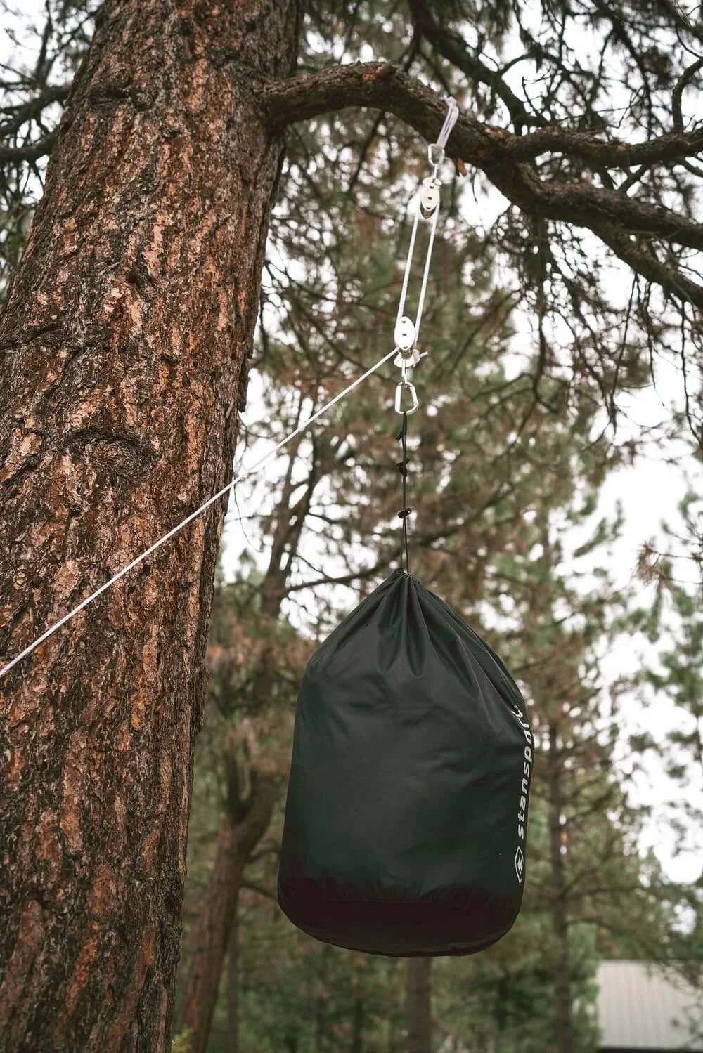 Heavy Duty Indoor Outdoor Pulley Hoist With Chromed Pulleys Polypropylene Rope 440 Lb Capacity 65 Ft suspending a bag from a tree