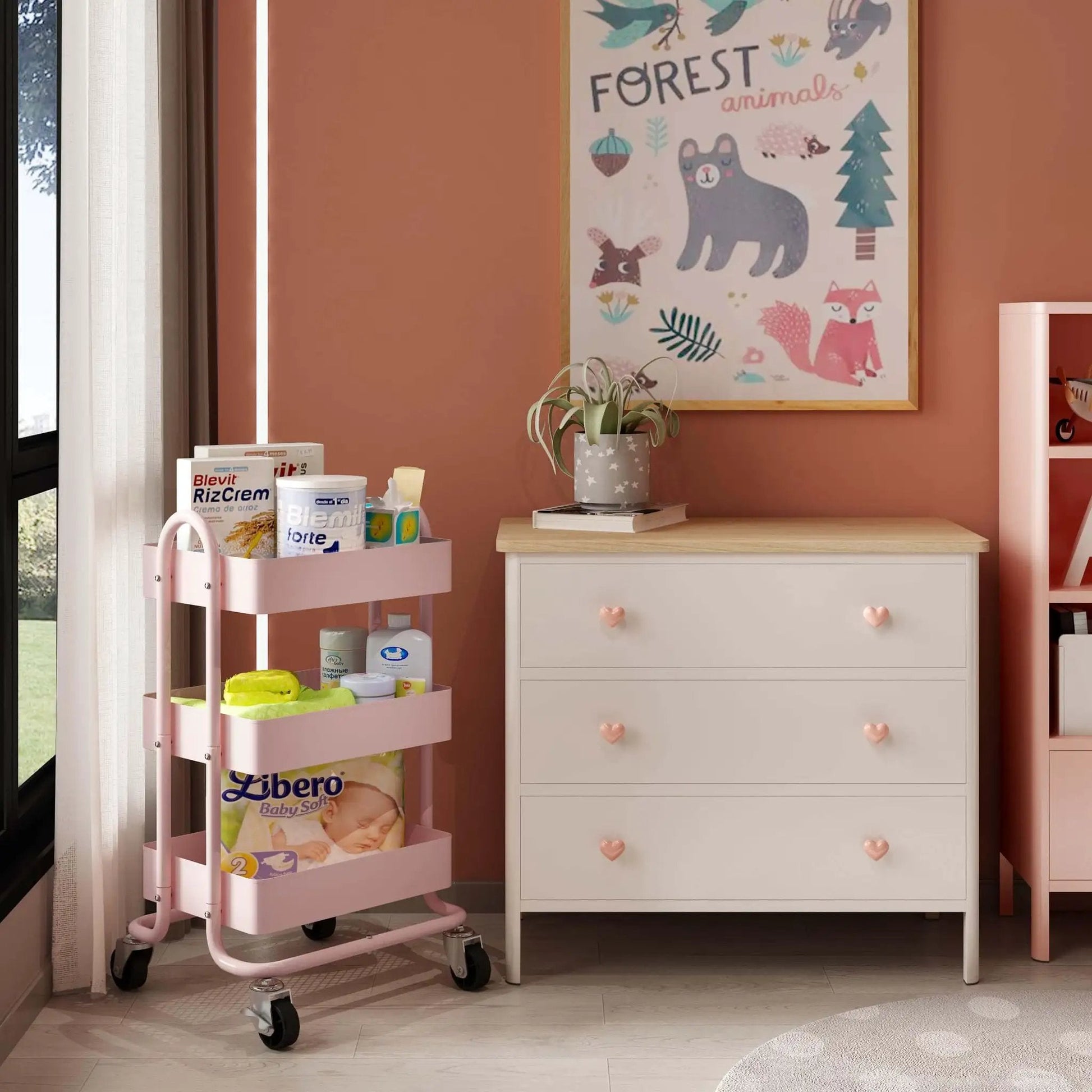 Pink 3 Tier Utility Rolling Cart On Wheels For Kitchen Office Home And Garden Elitehouse Metal Storage Cart With Locking Wheels Durable Mobile Organizer 13.4 By 18.1 By 31 Inches placed beside a white dresser in a children's room.