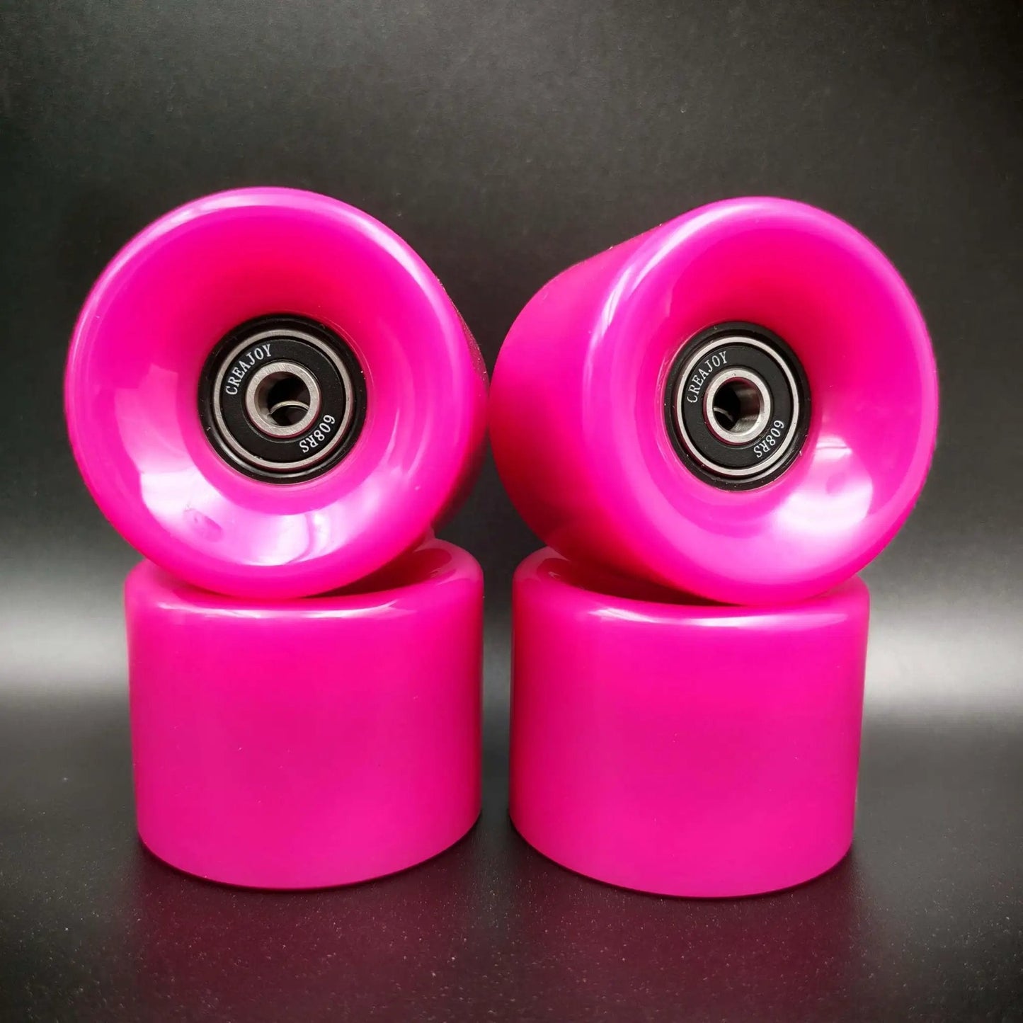 Pink 60mm skateboard wheels with bearings set of 4 92a hardness ideal for street and park, shown stacked on black surface