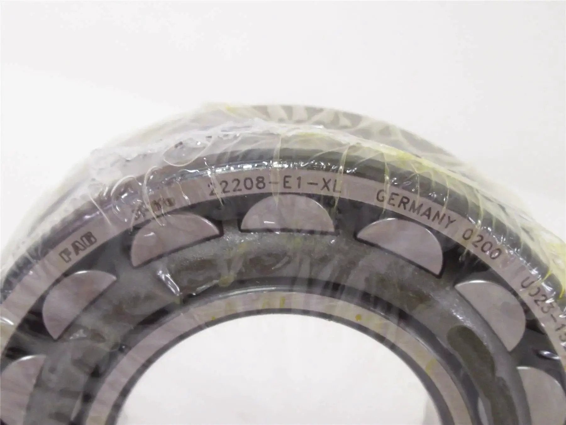 Close-up of high precision spherical roller bearing 22208 E1 XL 40x80mm with sealed design, showcasing markings and structure.