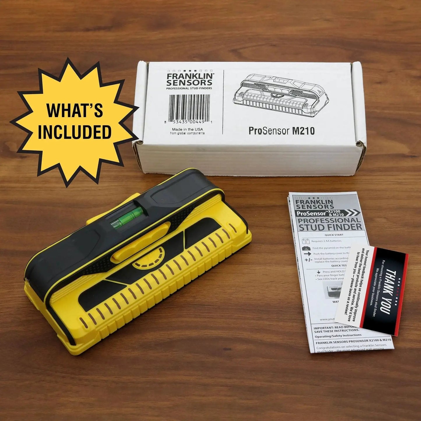 ProSensor M210 13-sensor stud finder with box and instruction manual on wooden surface.
