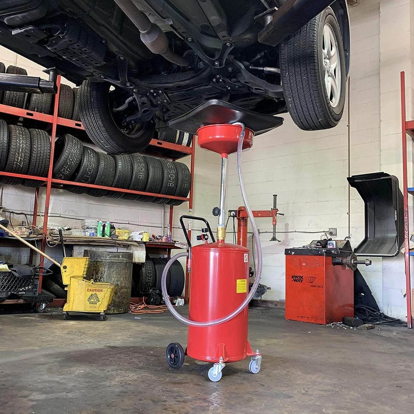 Lincoln 3601 Pneumatic 18 Gallon Pressurized Fluid Drain and Evacuation Tank under vehicle in garage setting