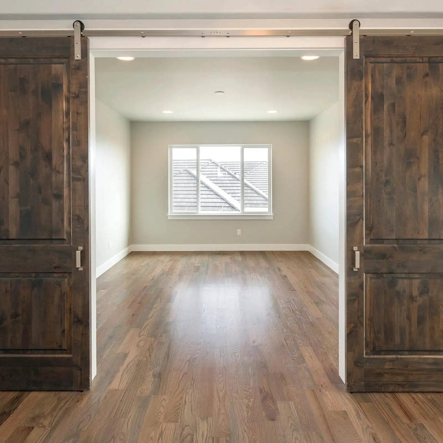 Wooden sliding doors with visible track system in a spacious room, showcasing installation for Sliding Door Nylon Wheel Pulleys 30mm.