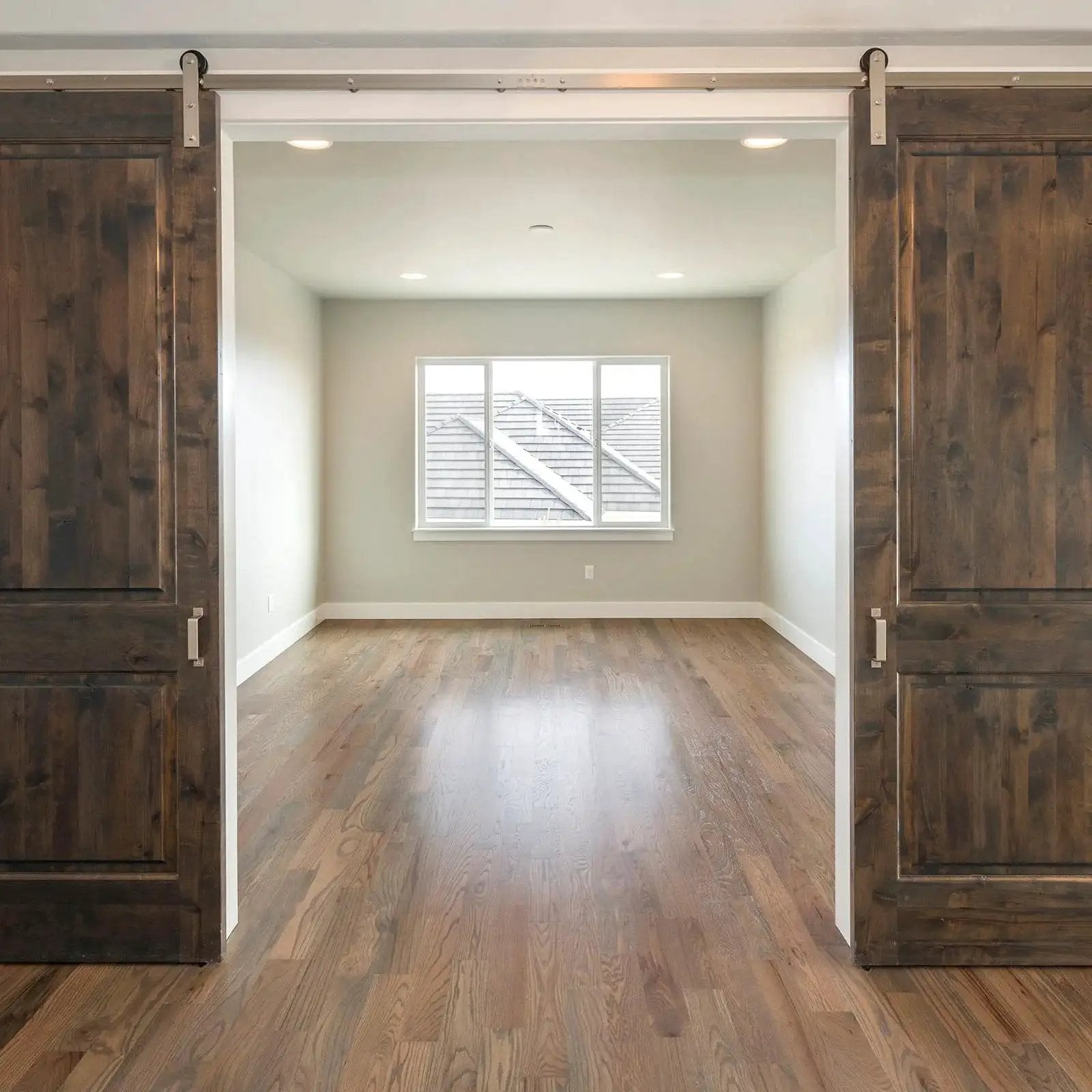 Wooden sliding doors with visible track system in a spacious room, showcasing installation for Sliding Door Nylon Wheel Pulleys 30mm.