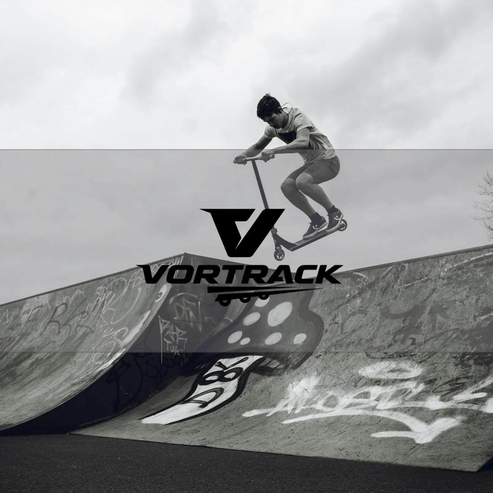 Skater performing a jump on half-pipe with Vortrack logo in foreground, monochrome image