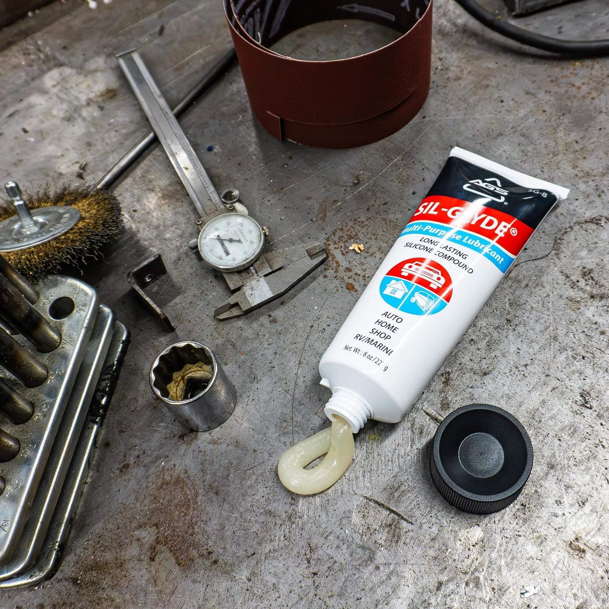 SIL-Glyde Multi-Purpose All-Weather Lubricating Compound for All Surfaces - 8 oz Tube on workshop table with tools