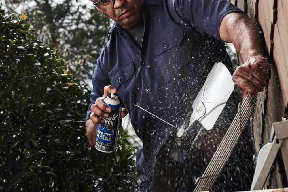 Man using Heavy Duty Lubricating Oil For Tools And Machinery 11 Oz Keeps Moving Parts Slick Quiet And Rust Free Perfect For Hinges Chains Sprockets Locks And Small Engines A Trusted Workhorse From Liquid Wrench on garden tool.