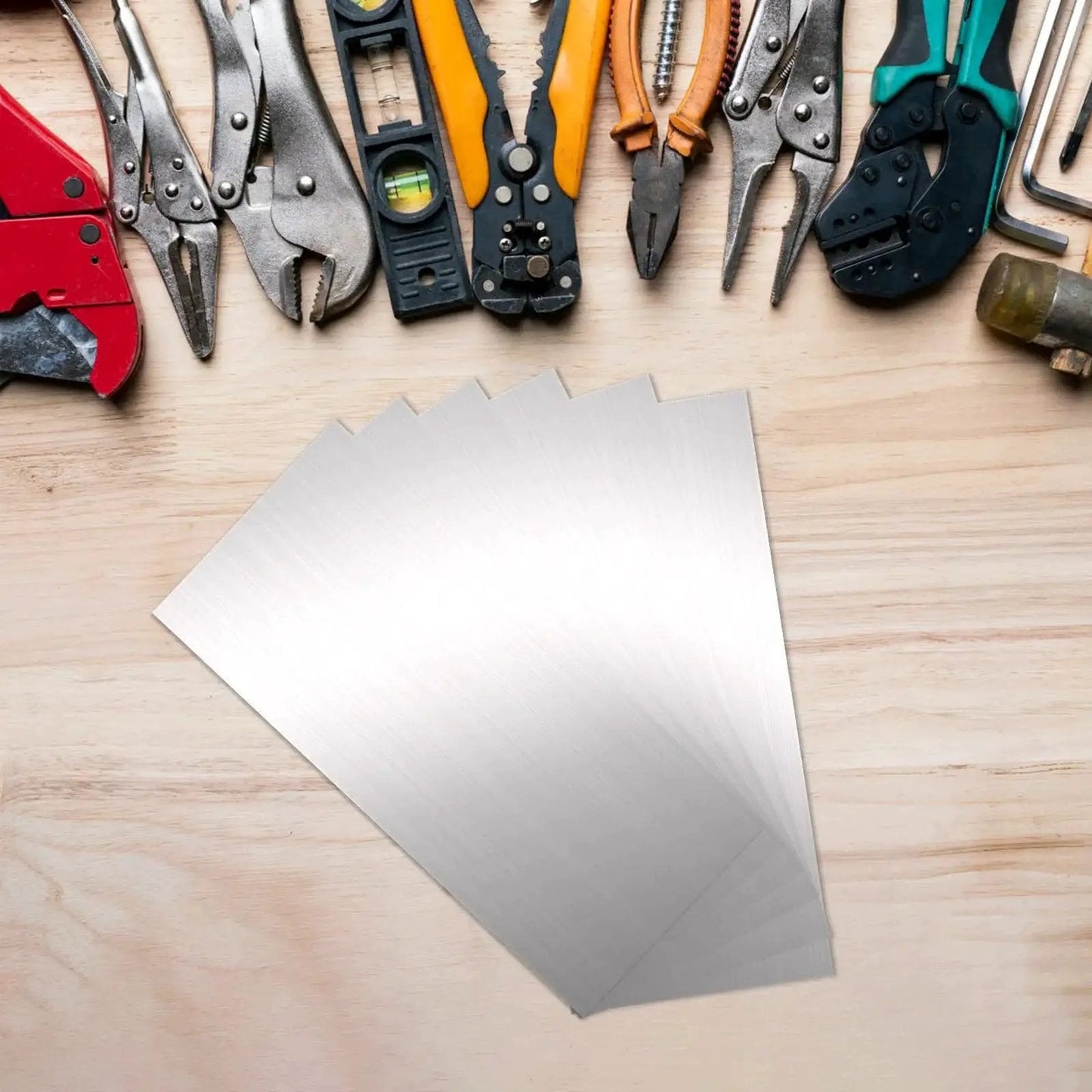 12 Piece Stainless Steel Shim Stock Kit 2.5 x 6 Inch For Leveling And Spacing next to various tools on a wooden surface