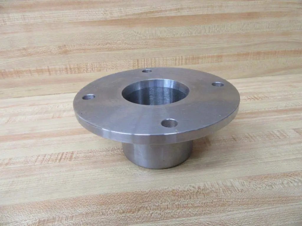 Beefy Industrial Grade Stainless Steel Bushing Holder For Heavy Duty Machinery With Three Inch Height Inner Diameter Two And Three Quarter Inches Outer Diameter Seven Inches Size Seventy Rexnord 4310070HZ, shown in side view on wooden surface.