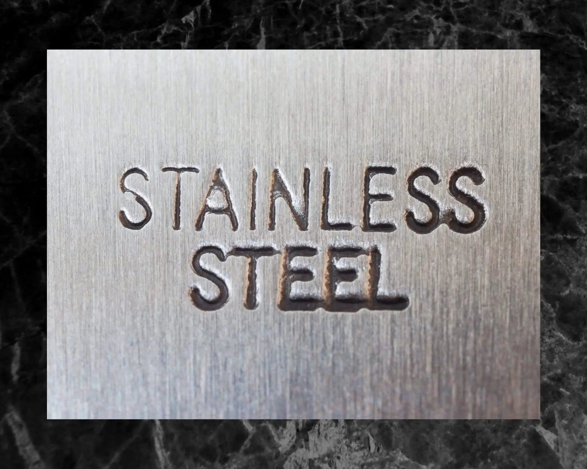 Close-up of the text 'Stainless Steel' engraved on a metal surface for Three Sixteenth Inch 440 Stainless Steel Bearing Balls Grade G25.