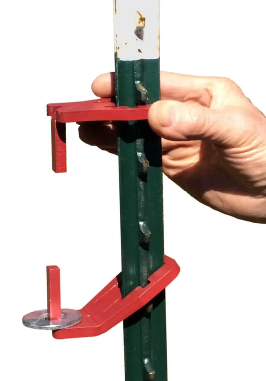 Hand holding patented T post hinge pins for easy gate hanging from metal T posts, made in USA, fully patented farm gate hardware kit