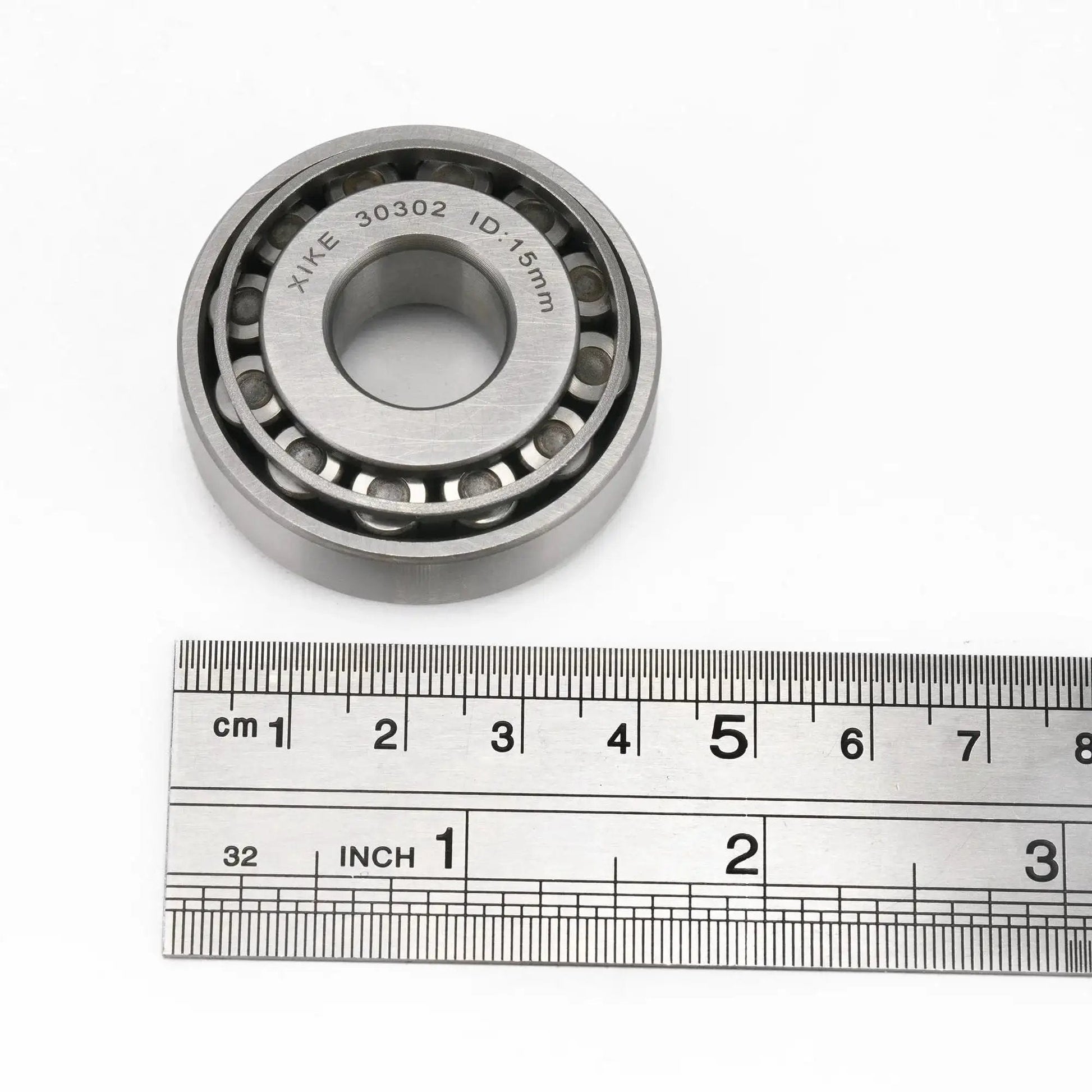 Two Piece 30302 Tapered Roller Bearing Cone And Cup Set 15x42x14.25mm with ruler for scale, chrome steel for cars and machinery