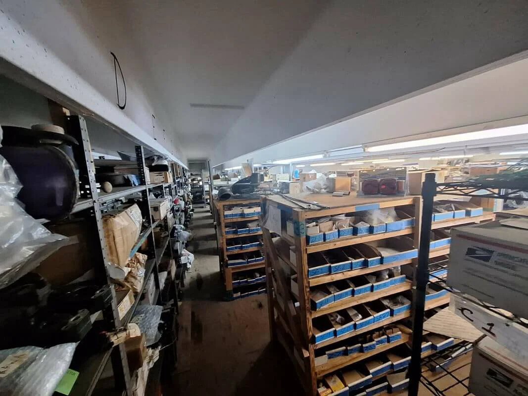 Warehouse shelves stocked with marine equipment and 777-9001 Marine Pulley Driven Flexible Impeller Pedestal Mount Pumps.