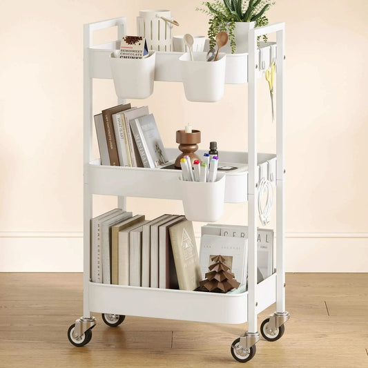 Versatile 3 Tier Rolling Cart With Locking Wheels Hanging Cups And Hooks Heavy Duty Metal Storage Organizer For Kitchen Office Bathroom Craft Room White Perfect For Spices Toiletries Craft Supplies Makeup And More shown loaded with books, plants, and utensils on wooden floor