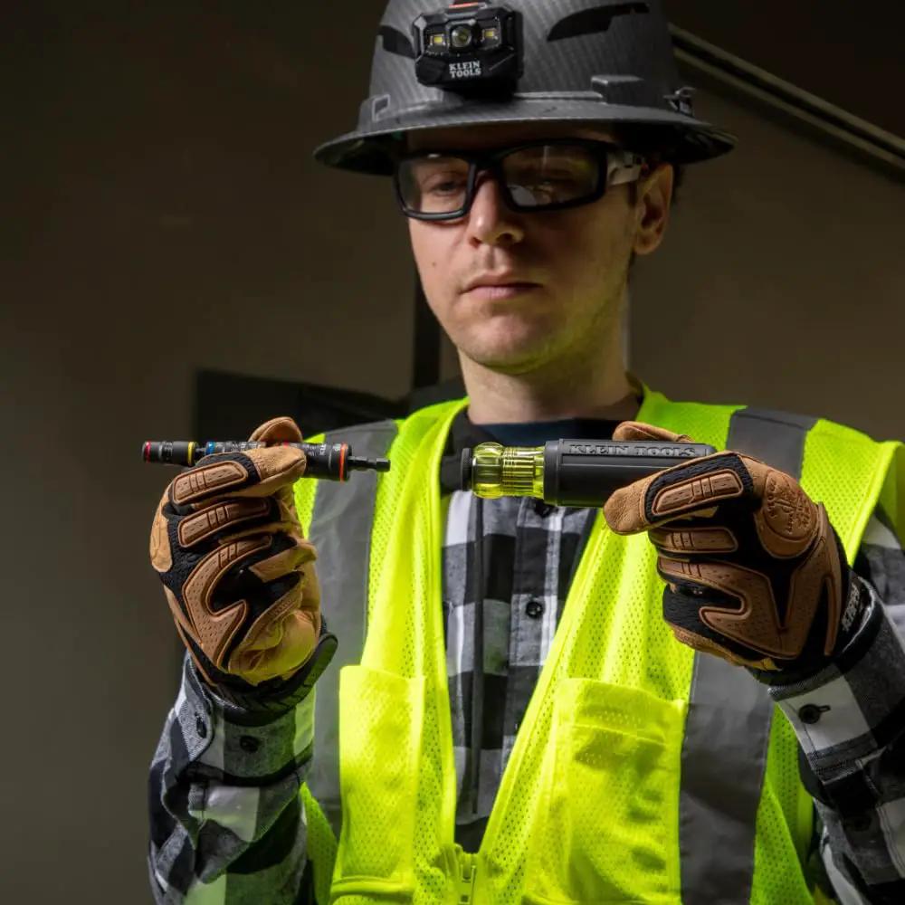 Person holding 7 In 1 Flip Socket Set For Impact Drivers With Handle And Bit Holder By Klein Tools, wearing safety gear